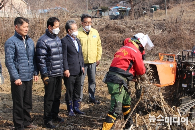 김명수 농협 조합장과 임원 임호석 의원이 영농부산물 파쇄기계의 작업현장을 지켜보고 있다